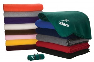 A stack of folded Custom Fleece Blankets in multiple colors with an example logo printed on one corner 