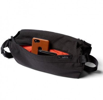 Bellroy Sling Bag in Black shown with a phone and other items inside