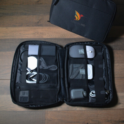 Landon Tech Bag shown open with tech accessories inside and lying on a table