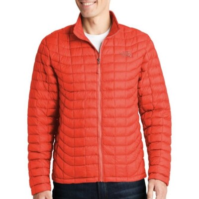 The North Face Unisex ThermoBall Trekker Jacket shown in Fire Brick Red on a male model