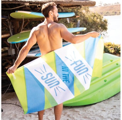 Traveler's Beach Towel shown in-use with a male model in a beach environment